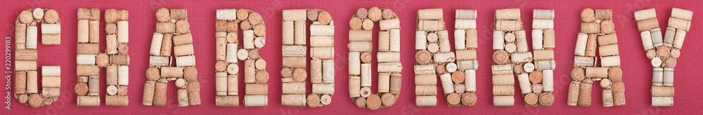 Grape variety Chardonnay made of wine corks on red Bordeaux background. ABC set, Burgundy color and wine berry