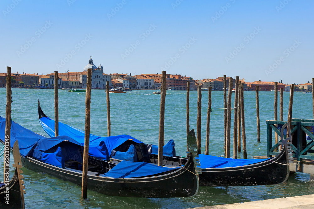 VENICE, ITALY - July 25 2018: Venetian gondolas on the water of the Canal Grande