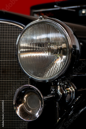 The headlight of an antique, rarity, vintage black car.