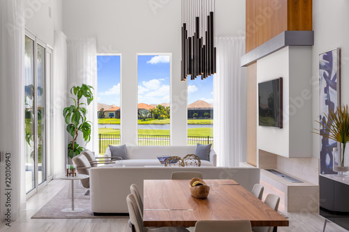 modern white and wood open plan dining room overlooking living room and golf course