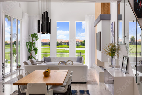 white open plan living and dining room with wood detailing overlooking golf course