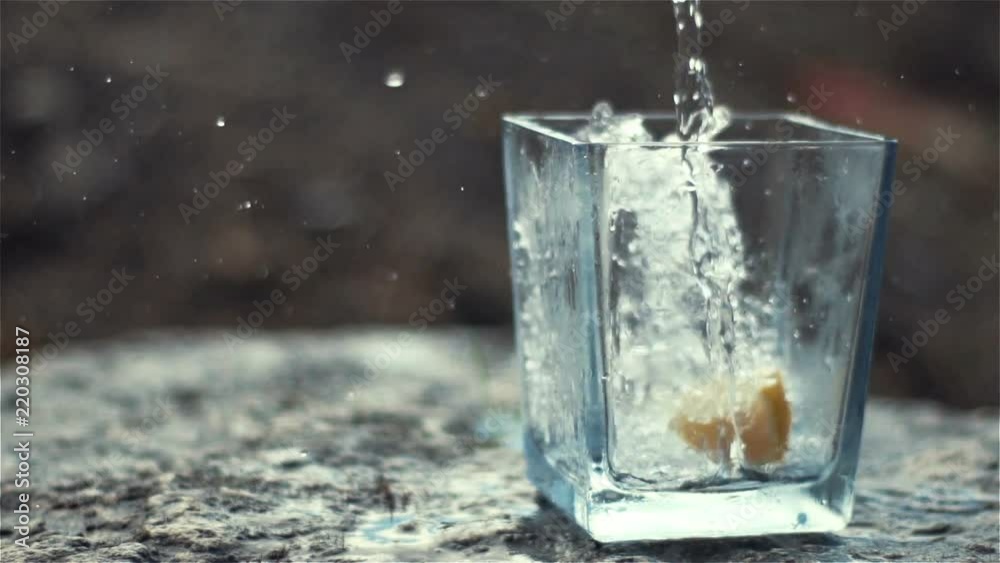 100fps Slow Motion of Sparkling Water and Lemon Falling into Glass 100fps Slow Motion of Sparkling Water and Lemon Falling into Glass