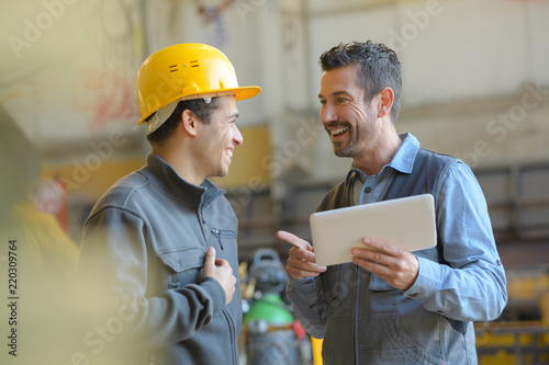 Canvas Print workers talking and laughing at a factory