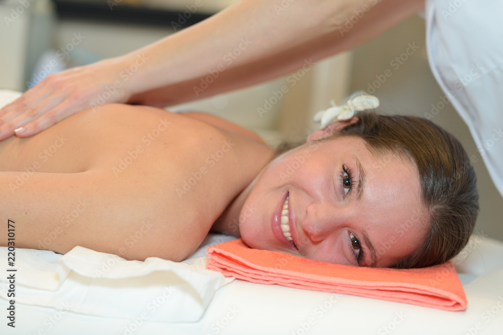 young beautiful girl lying on massage table enjoying massage young beautiful girl lying on massage table enjoying massage