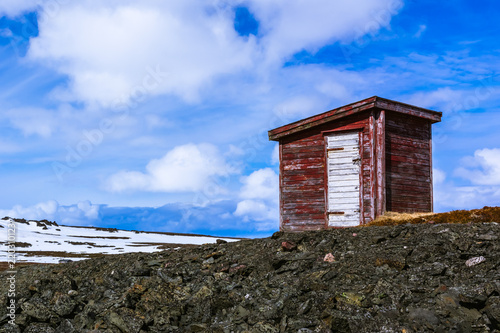Red wooden shed standing on the hill
