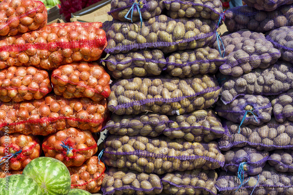 Potatoes and onions in bags of nets for transportation and sale