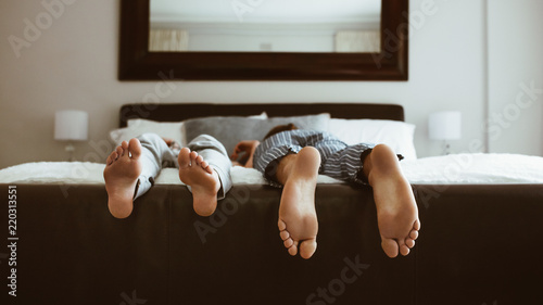 Close up of feet of couple sleeping on bed