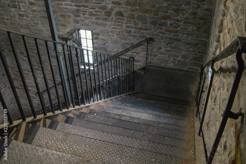 Inside metal stairwell with stone walls, no people, interior