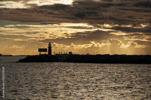 Sunset view of a lighthouse by the bay