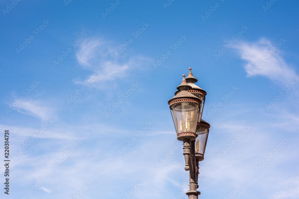 Beautiful antique street lamp set against a blue sky and fluffy clouds. Beautiful antique street lamp set against a blue sky and fluffy clouds.