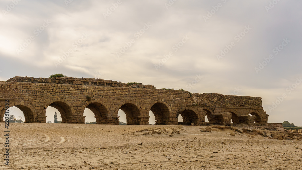 Ancient Roman ruins of aqueduct in Ceasarea Israel historical monument.
