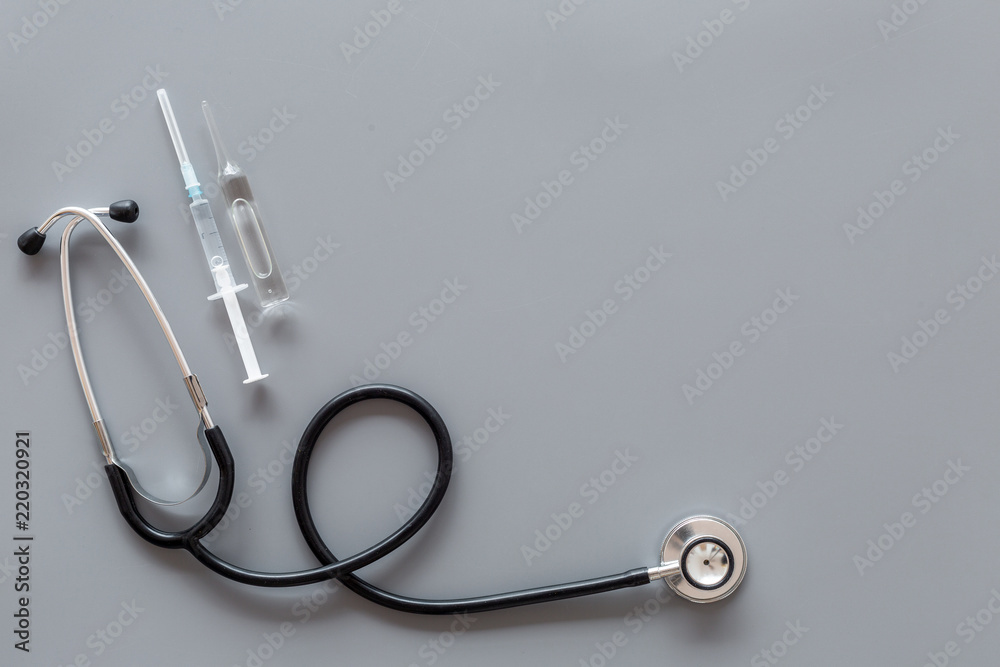 Infuenza, flu vaccine in syringe near stethoscope on grey background top view copy space - obrazy, fototapety, plakaty 