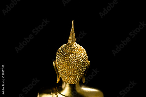 behind golden buddha against a black background