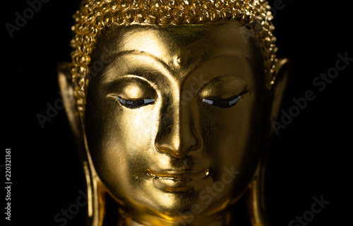 Smiling buddha against a black background