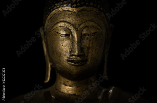 Smiling buddha against a black background