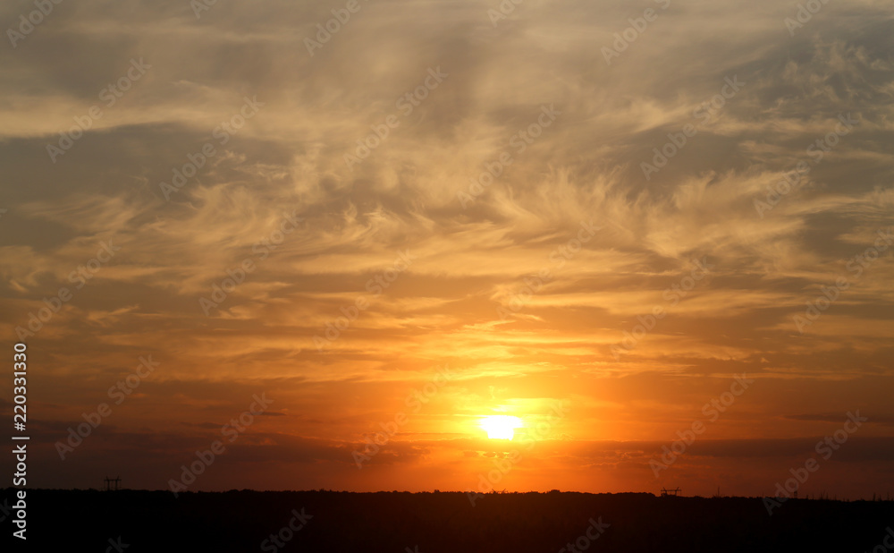 Beautiful photo of a bright sunset with clouds over a field Beautiful photo of a bright sunset with clouds over a field