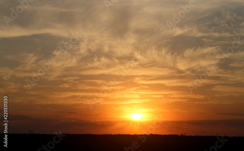 Beautiful photo of a bright sunset with clouds over a field