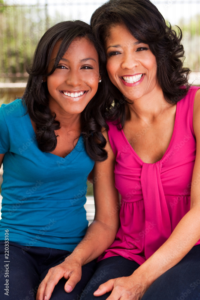 African American mother and daughter hugging and smiling. African American mother and daughter hugging and smiling.