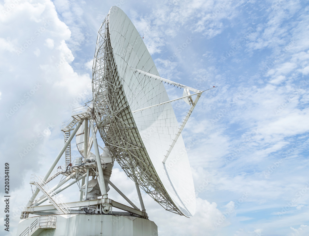 large white satellite dish turn up skyward on blue sky in earth communication antenna system center station