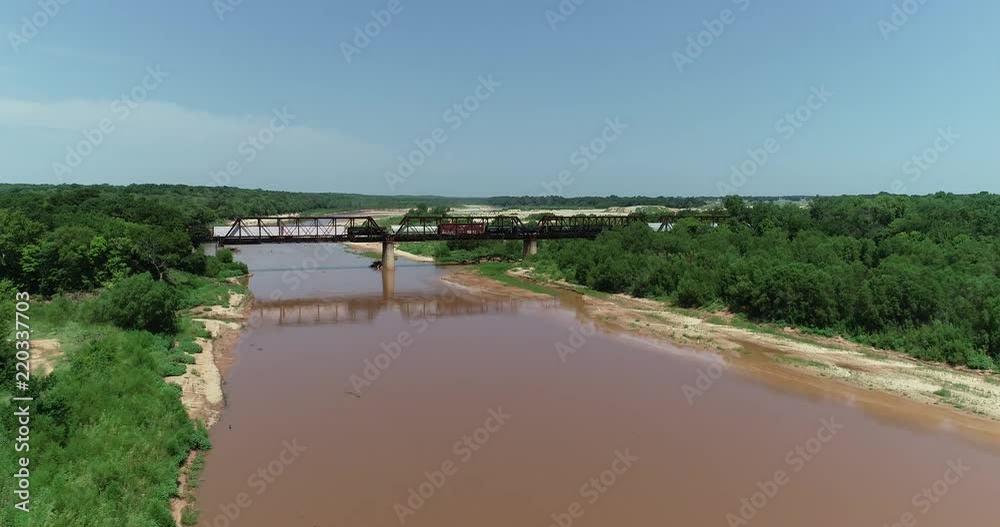 Aerial video of the Red River which borders between Texas and Oklahoma. This was shot just west of where highway 35 crosses the river into Oklahoma. A train is crossing the bridge. Aerial video of the Red River which borders between Texas and Oklahoma. This was shot just west of where highway 35 crosses the river into Oklahoma. A train is crossing the bridge.