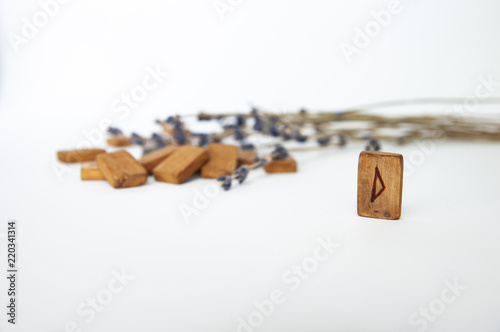 Thurisaz. Scandinavian runes. Wooden runes on a table on a white background.