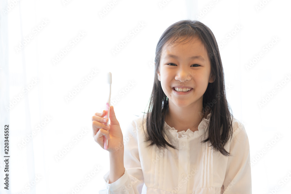 Asian girl smiles and holds a toothbrush,healthy teeth concept Asian girl smiles and holds a toothbrush,healthy teeth concept