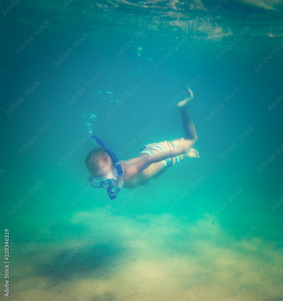 Kid boy diving underwater