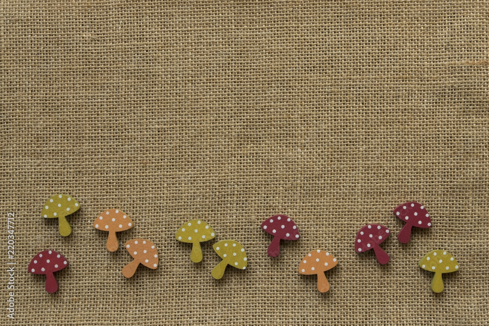 Bordüre aus Pilzen in Herbstfarben auf Hintergrund aus Jute abstrakt Bordüre aus Pilzen in Herbstfarben auf Hintergrund aus Jute abstrakt