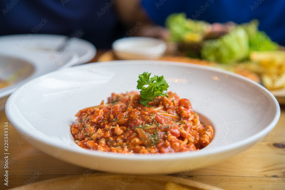 Spaghetti with minced pork tomato sauce on white dish in restaurant Spaghetti with minced pork tomato sauce on white dish in restaurant