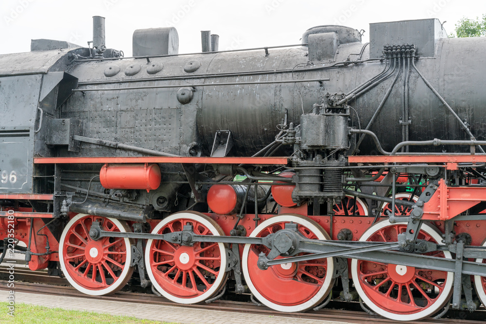 Steam locomotive with red wheels. Retro locomotive on rails.