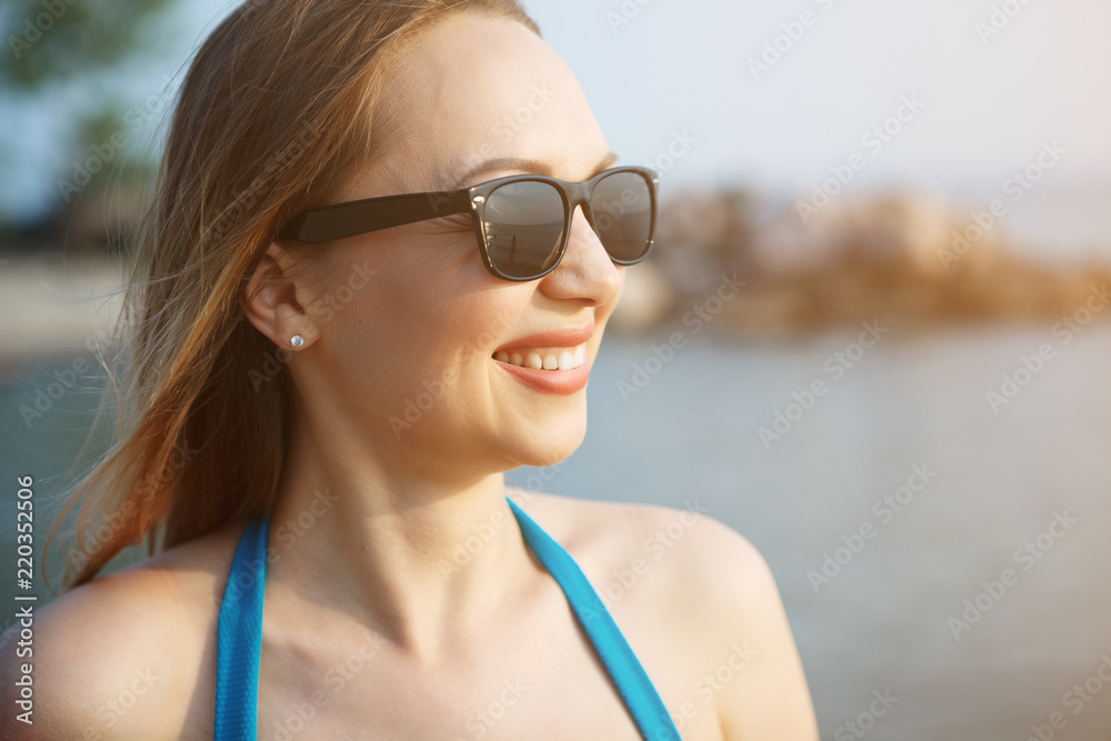 Young pretty woman in a blue swimsuit is walking along a sandy beach by the sea. Young pretty woman in a blue swimsuit is walking along a sandy beach by the sea.