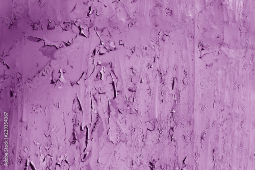 Grungy metal wall with peeling paint in purple tone.