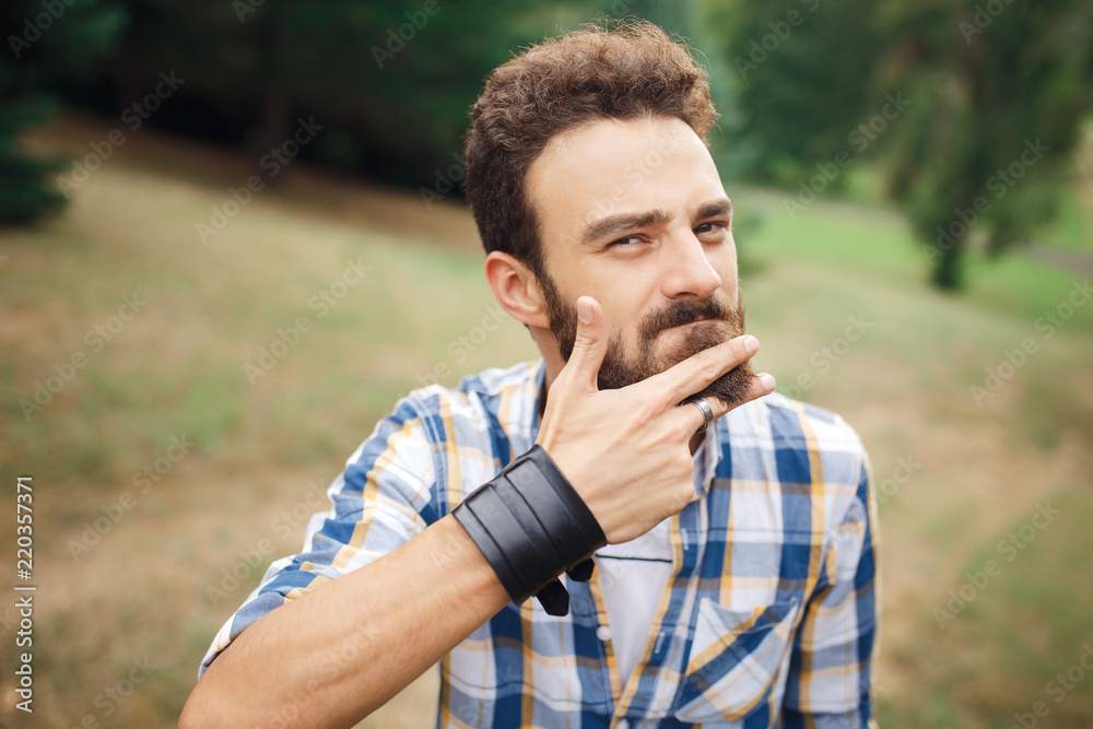 Young bearded hipster cut the beard with finger. Barbershop concept. Young bearded hipster cut the beard with finger. Barbershop concept.