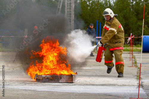Competitions firefighters. The fireman works with a fire extinguisher to extinguish the fire...