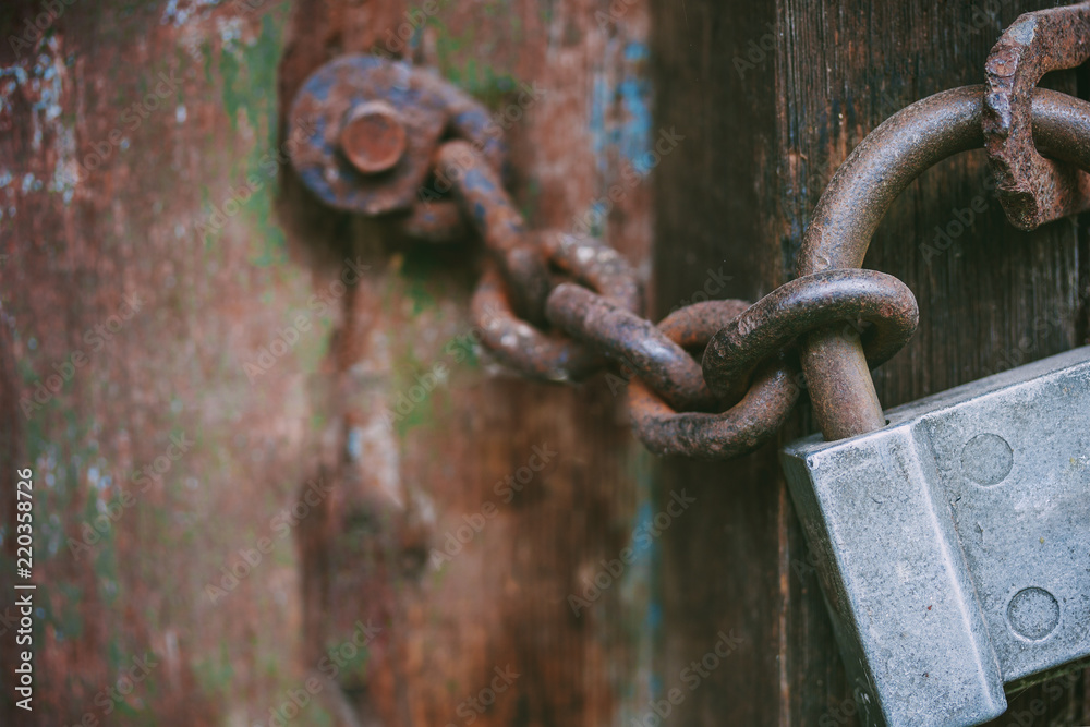 An old scratched замок with a metal chain closes the door, details, macro, blurry