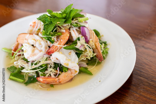 Close up image of Shrimp salad with lemon grass and mint. Put on wooden table.