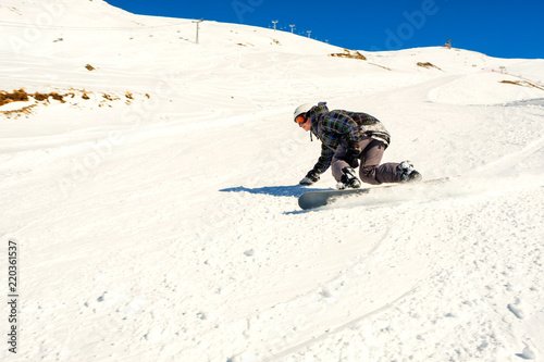 A young guy on a snowboard at a ski resort