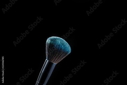 makeup brush with powder on black background