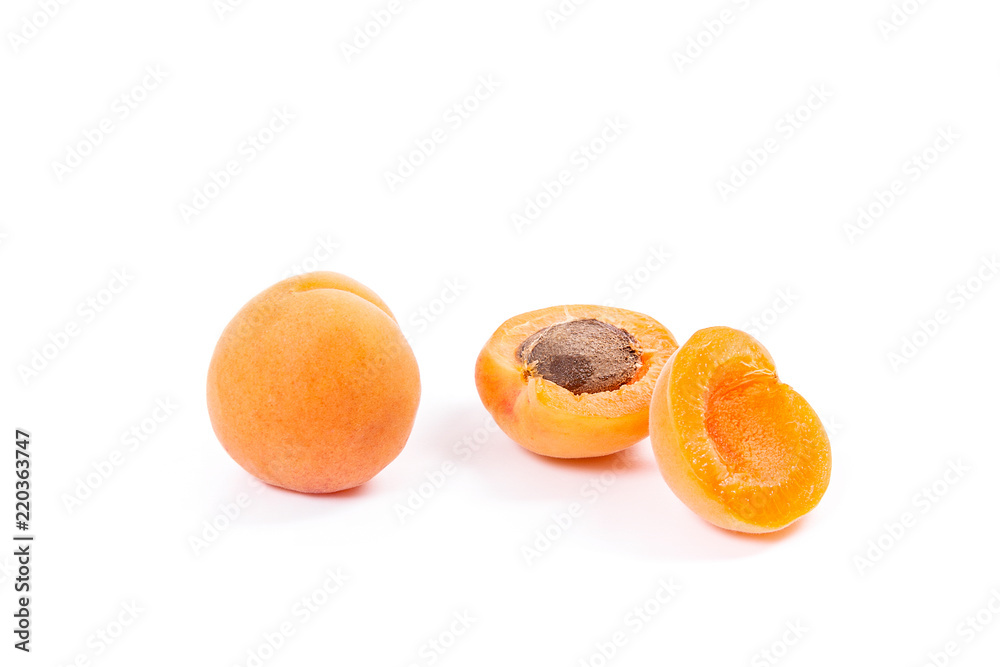 Several of harvested apricots whole and halved on white background..