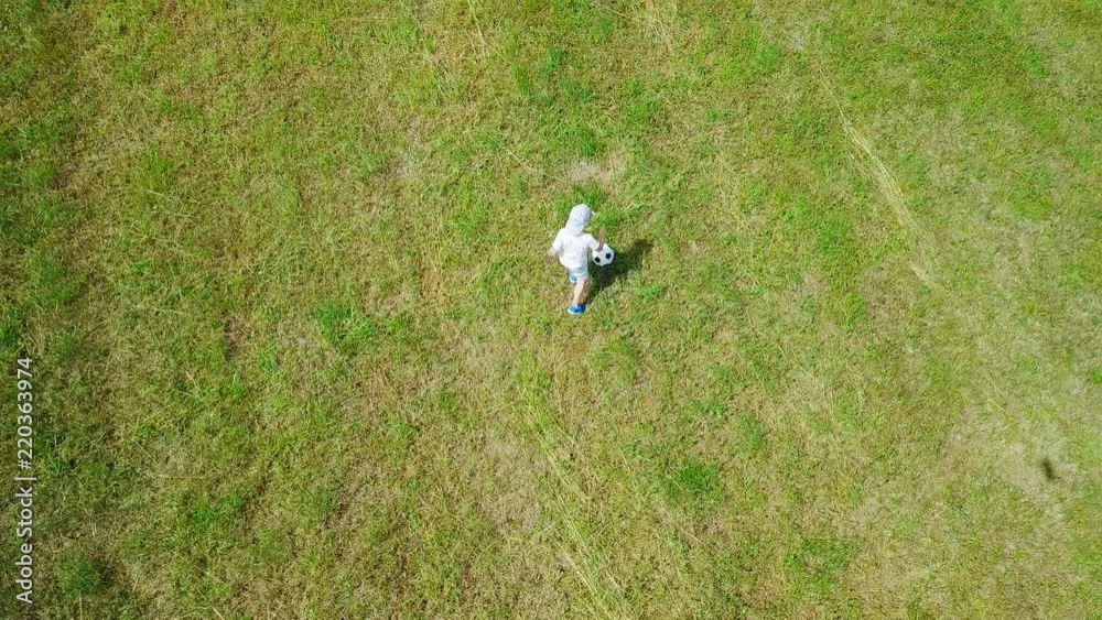Aerial View happy child playing together with ball in football on summer day, green grass and field background, Drone 4K Video
Aerial View happy child playing together with ball in football on summer day, green grass and field background, Drone 4K Video