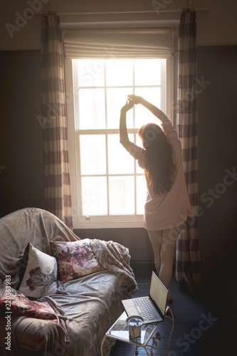 Woman standing near window at home photo