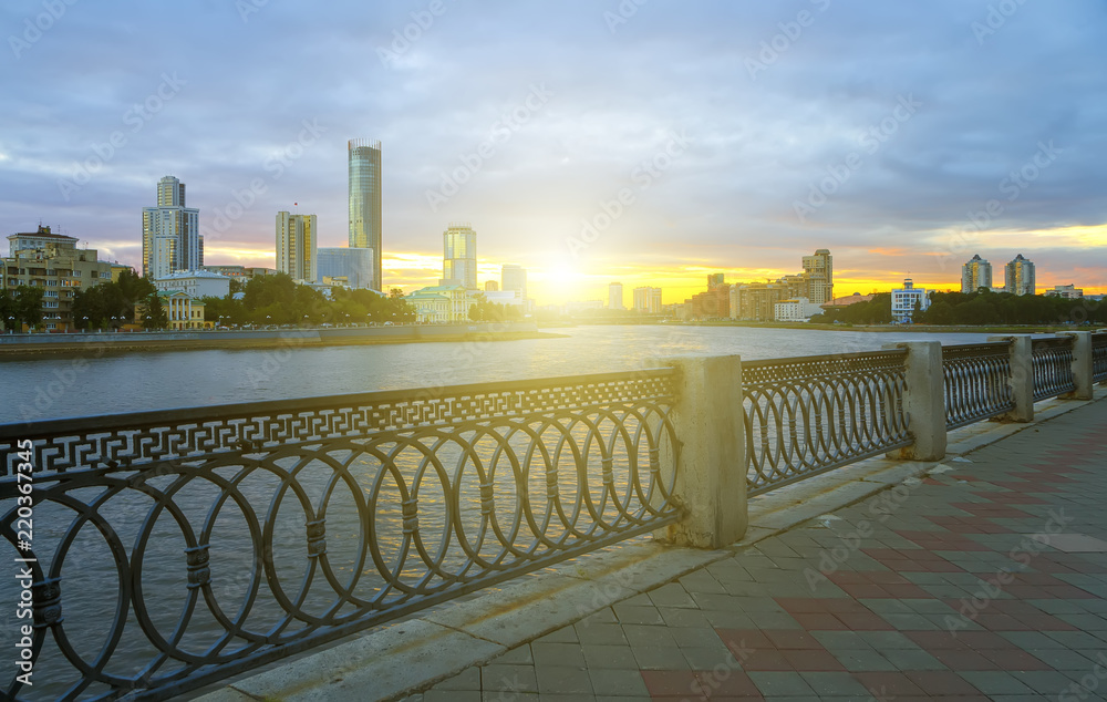 Obraz premium Yekaterinburg city center on sunset. City pond view, amazing clouds and sky. High buildings, skyscrapers on the embankment of the river Iset.