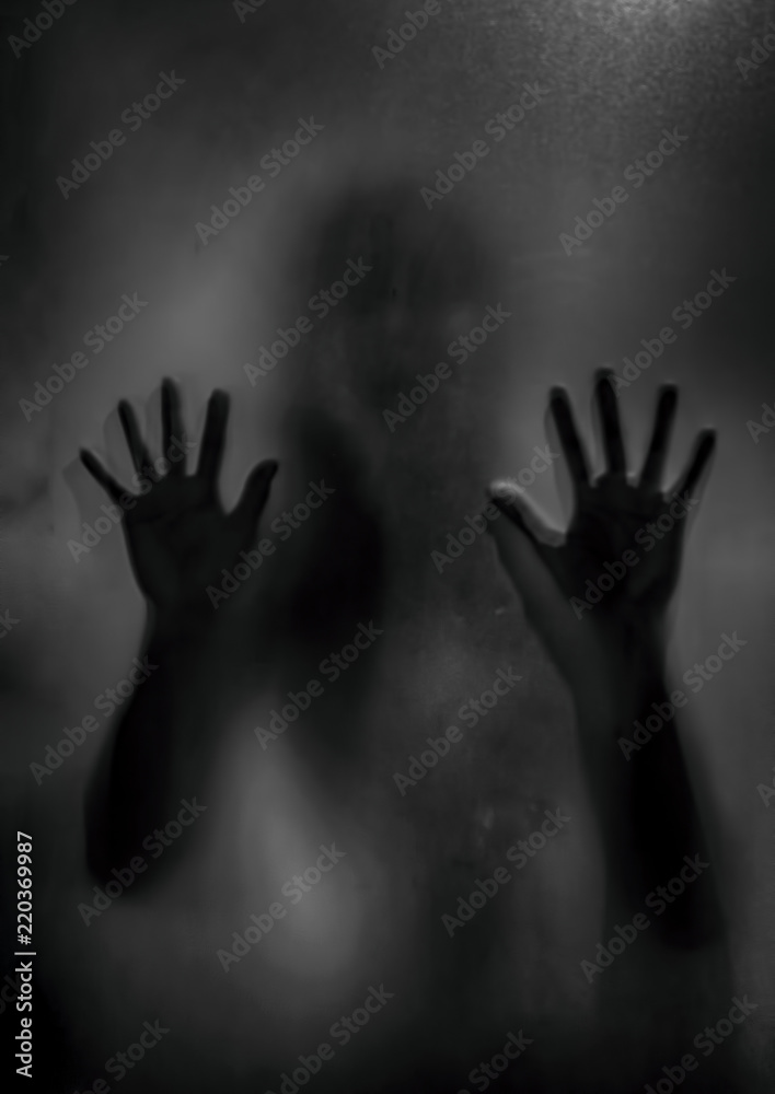 Horror ghost girl behind the matte glass in black and white. Halloween festival concept.