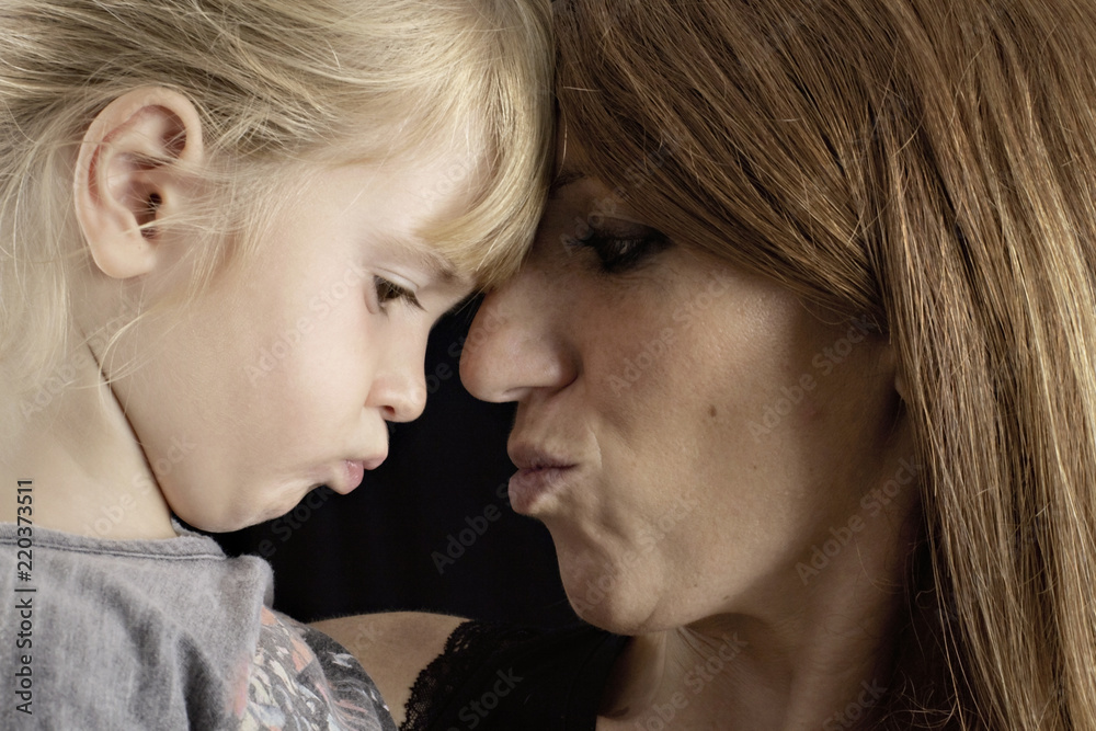 A loving caring mother throwing a kiss in the air at her daughter. Studio shot.
A loving caring mother throwing a kiss in the air at her daughter. Studio shot.