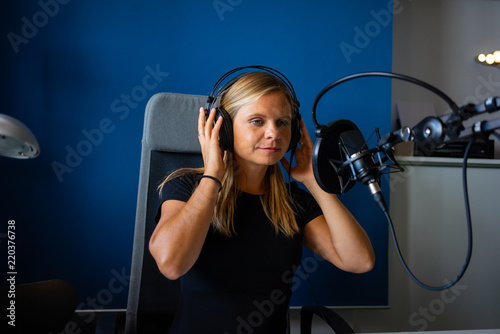 mujer grabando un podcast en un estudio