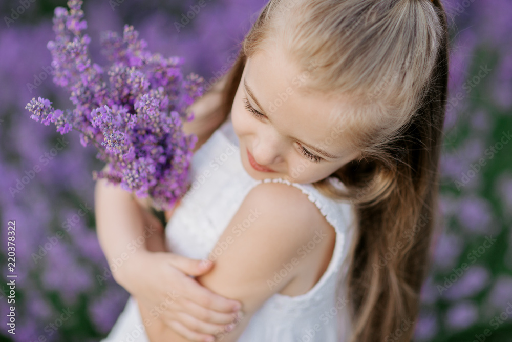 Happy cute little girl in lavender field holding bouquet of purple flowers. Happy cute little girl in lavender field holding bouquet of purple flowers.