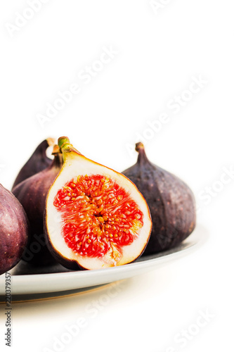 Fresh figs on grey plate. Fruit with half isolated on white.