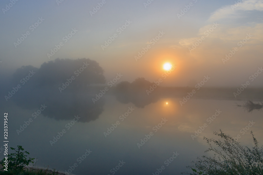 Fog above the river surface. River landscape at sunrise in summer morning