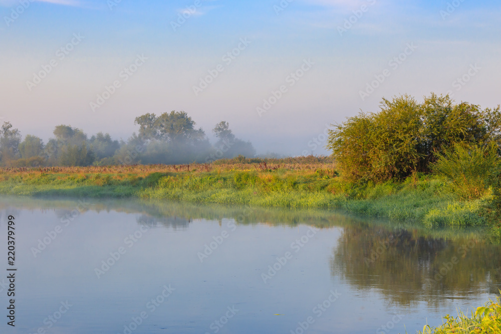 River landscape at sunrise against blue sky in summer morning