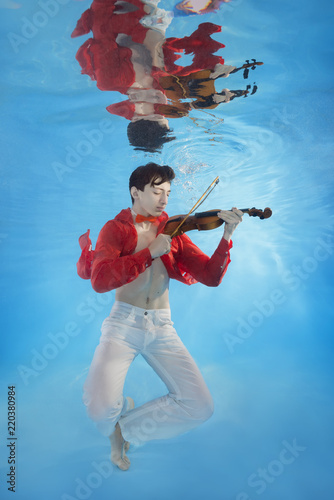 Obraz na plátně Teenager plays the violin underwater